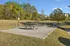 Charming outdoor area featuring picnic tables, vibrant playground, and lush greenery, ideal for family gatherings and relaxation.
