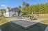 Charming apartment building with an inviting outdoor area featuring picnic tables and scenic wooded views.