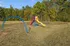 Inviting playground with vibrant slide and swings in a spacious, scenic park setting surrounded by lush greenery.