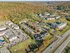 Scenic aerial view of a picturesque apartment community surrounded by vibrant autumn foliage, highlighting expansive green spaces and a well-organized network of roads and parking areas.