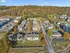 Scenic aerial view of a charming residential community nestled among vibrant autumn trees, featuring well-maintained apartment buildings, ample parking, and a community pool.