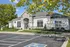 Charming clubhouse exterior with lush landscaping and accessible parking, perfect for community gatherings.