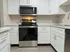 Modern kitchen with sleek stainless steel appliances, elegant white cabinetry, and chic marble countertops, perfect for culinary enthusiasts.