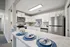 Chic modern kitchen with stainless steel appliances, elegant white cabinetry, and a stylish breakfast bar set for two.