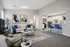Chic living room with modern decor, cozy seating, abstract art, and open-concept kitchen with blue bar stools.