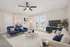 Inviting living room with chic blue armchairs, plush sofa, and elegant decor, featuring large windows for abundant natural light.