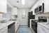 Contemporary kitchen with sleek stainless steel appliances, pristine white cabinetry, and elegant marble countertops.