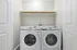Modern laundry nook featuring sleek Samsung washer and dryer with convenient overhead shelving.
