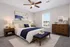 Elegant bedroom with modern furnishings, featuring a plush bed, cozy lighting, and a serene landscape artwork, designed for comfort and style.