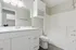 Sleek modern bathroom with elegant vanity, ample storage, and pristine bathtub in a serene setting.