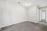 Bright and inviting empty room with plush carpet and smooth neutral walls, leading to a hallway with multiple doorways, ideal for personalization.