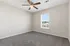 Bright and airy bedroom with plush carpeting, ceiling fan, and ample natural light from large window.