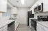 Modern kitchen with sleek white cabinets, stainless steel appliances, and a spacious marble countertop.