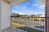 Inviting balcony view overlooking a serene neighborhood with bright blue skies and charming homes.