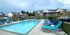 Charming residential community with inviting swimming pool, sun loungers, and ample seating, surrounded by modern brick apartment buildings.