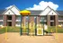 Charming apartment complex with classic brick facade featuring a vibrant playground, perfect for family-friendly living.