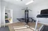 Bright and inviting home gym with modern workout equipment, featuring a treadmill and multi-station machine in a spacious room with natural light.