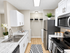 Contemporary kitchen with sleek stainless steel appliances, stylish white cabinetry, and elegant marble style countertops, perfect for culinary enthusiasts.