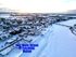 Breathtaking winter aerial view of a snowy townscape in Fort Fairfield, Maine, showcasing serene landscapes and peaceful residential areas alongside a frozen river under a setting sun.