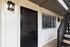 Welcoming apartment entrance with a modern black door and charming outdoor light fixture.