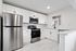 Modern kitchen with sleek stainless steel appliances, elegant white cabinetry, and stylish marble-patterned flooring.