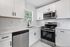 Modern kitchen with sleek stainless steel appliances, elegant white cabinetry, and a chic subway tile backsplash.