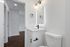 Chic and modern bathroom with elegant fixtures, sleek white vanity, and hardwood flooring creating a luxurious atmosphere.