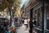 Charming street view with bustling pedestrians outside a bookstore, highlighting a lively urban lifestyle.