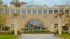 Majestic building facade with striking dinosaur sculptures on display in a beautifully landscaped area.