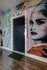 Vibrant urban apartment entrance with bold graffiti art and sleek hardwood flooring.