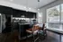 Sleek modern kitchen with black cabinetry, stylish hexagonal backsplash, and large windows providing abundant natural light.