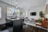 Modern living area with elegant furniture, featuring a chic kitchen island, stylish leather sofa, cozy decor, and natural light through large windows.
