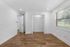 Bright and spacious bedroom with elegant wooden flooring, large window for natural light, and a convenient built-in closet.