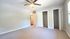 Bright, serene bedroom featuring a spacious closet, plush carpeting, and modern ceiling fan.