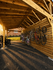 Inviting wooden bike storage shed showcasing convenient vertical racks, bathed in warm sunlight, perfect for an active lifestyle.