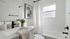 Bright and elegant bathroom featuring sleek fixtures, modern design, and abundant natural light.
