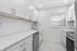 Sleek and modern kitchen featuring white cabinetry, stainless steel appliances, and a bright, airy atmosphere.