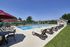 Dog-Friendly Apartments in Millersville, PA - Millers Crossing Apartments - Pool with Lounge Chairs, Tables, Umbrellas, and a Fence Surrounding It