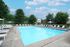 Apartments In Monroeville, PA - Stonecliffe - Gated Pool With Lounge Chairs, Umbrellas, And Tables.
