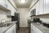 Modern kitchen with stainless steel appliances, granite countertops, and white cabinetry.