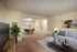 Stylish living room with modern decor, featuring a sleek gray sofa, a wooden coffee table, and contemporary wall art.
