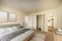Inviting bedroom with a plush bed, soft lighting, and spacious closet.