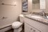 Elegant bathroom with granite countertop, modern fixtures, and serene artwork.