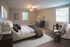 Luxurious bedroom featuring a plush bed, stylish decor, and ample natural light.