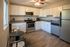 Charming kitchen with modern appliances, granite countertops, and white cabinetry.