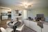 Bright open-concept living area with a cozy seating arrangement, elegant dining set, and a modern kitchen in the background.