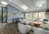 Spacious lounge featuring modern seating, large windows with natural light, and a ping pong table.