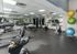 Spacious gym with modern equipment including treadmills, exercise bikes, and stability balls.