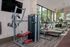 Modern fitness center with state-of-the-art equipment, including treadmills and strength machines, set in a bright, spacious area with floor-to-ceiling windows.
