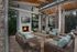 Modern outdoor lounge area with cozy wicker seating, a warm fireplace, and sleek wooden overheads, perfect for relaxing evenings.